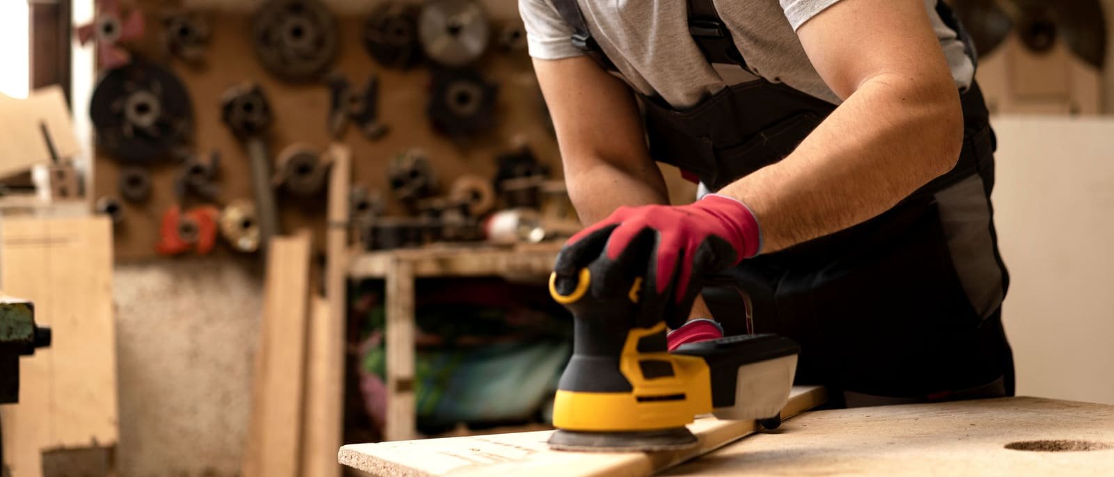 Instalador lijando un tablero de madera con lijadora orbital